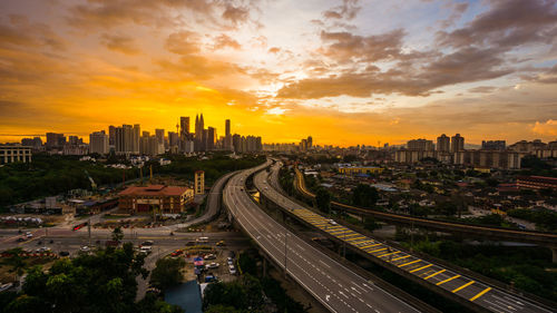 High angle view of street amidst buildings against sky during sunset