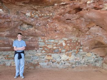 Rear view of woman standing against rock