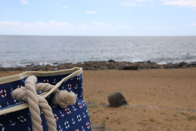 Toy on sand at beach against sky