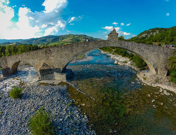 Medieval italian bridge with clear blue water 