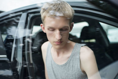 Close-up of young man seen through car window