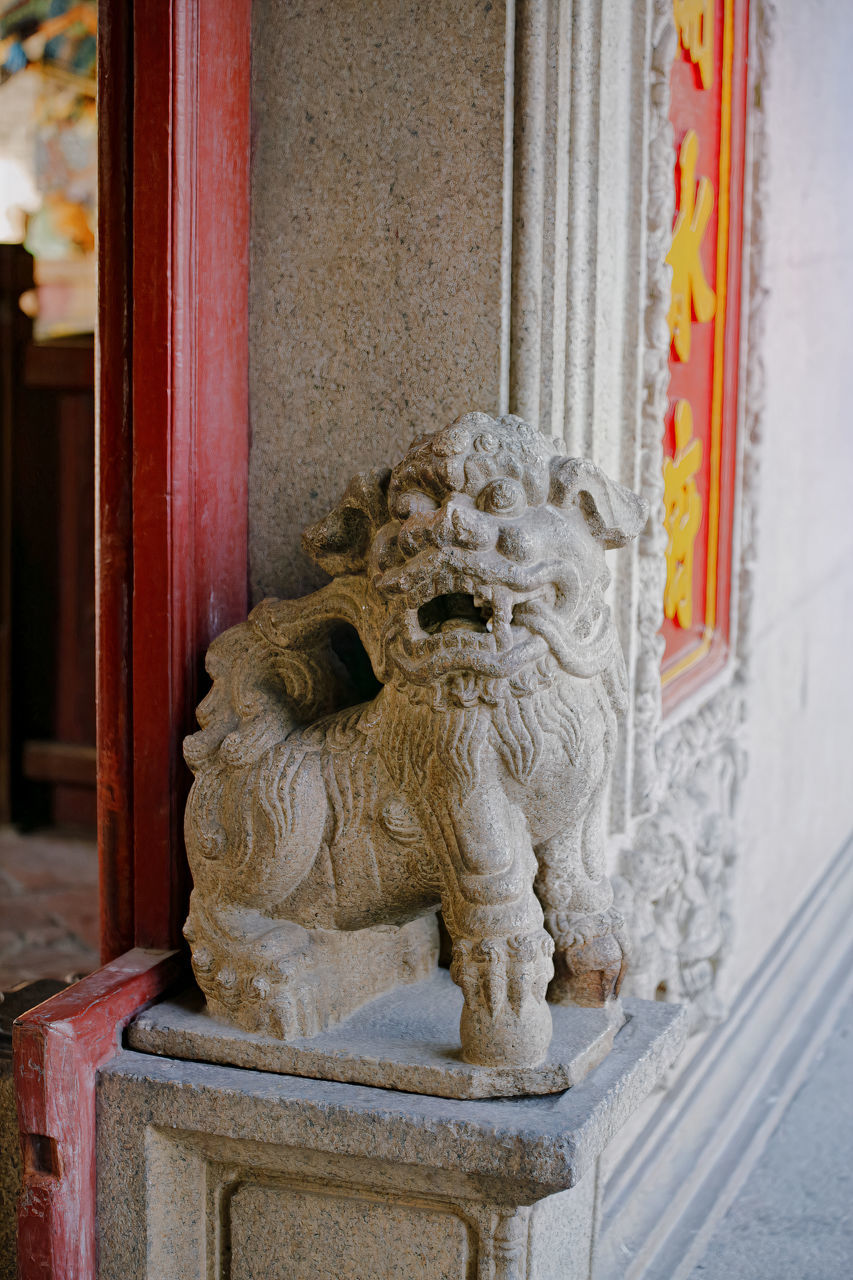 BUDDHA STATUE AGAINST BUILDING