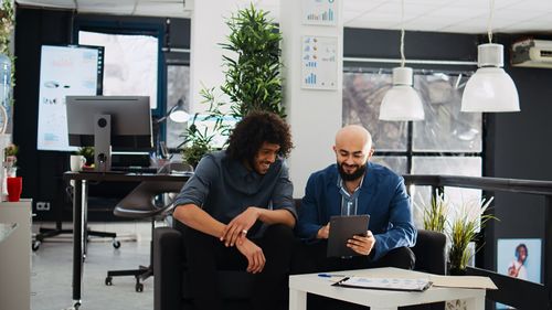 Side view of man using mobile phone while sitting on table