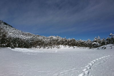 Snow covered landscape against sky