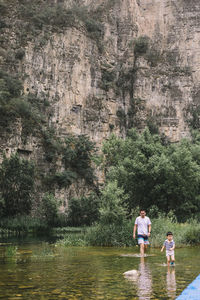 Rear view of people on rock against trees