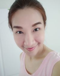 Portrait of smiling young woman against white background