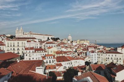 High angle view of town by sea against sky