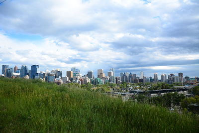 View of buildings in city against cloudy sky