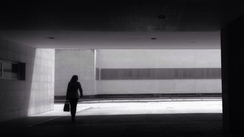 Rear view of woman walking in corridor