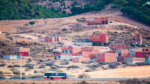 Car on road by houses on hill