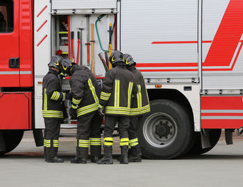 Firefighters standing against bus