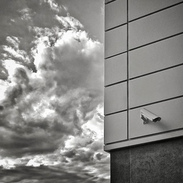 sky, low angle view, building exterior, cloud - sky, architecture, built structure, cloud, flying, cloudy, day, modern, no people, outdoors, airplane, building, city, transportation, bird, window, office building