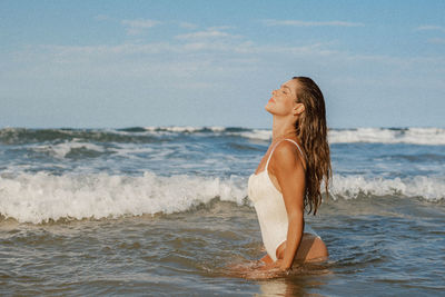 Portrait of young woman standing at beach