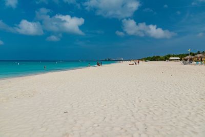 People at beach against sky