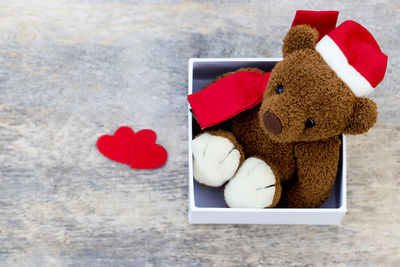 High angle view of teddy bear in box on wooden table