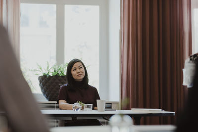 Businesswoman contemplating while sitting in corporate office