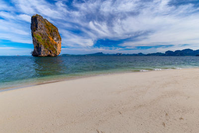 Rock formation on beach against sky