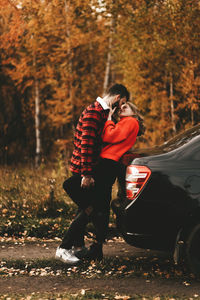 Rear view of women standing on street during autumn