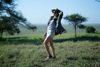 Full length of young woman standing on field