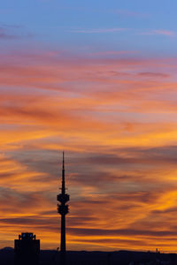 Low angle view of silhouette communications tower during sunset