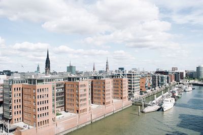 View of buildings in city against cloudy sky