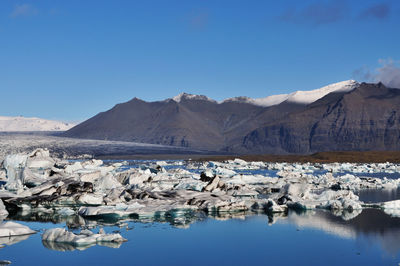 Scenic view of ice floe in lake against mountains
