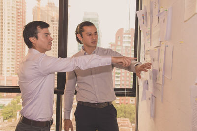 Businessman discussing graphs with colleague in office