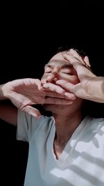 Cropped image of man holding food against black background