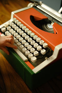 Children's hand presses space bar on orange vintage typewriter and wants to make pause. child learns