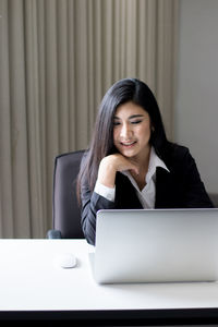 Businesswoman using laptop while working in office