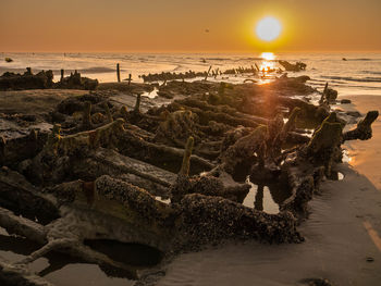 Wreckage of a world war ship at sunset close to the beach