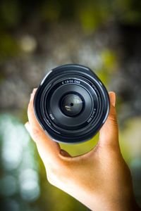 Close-up of hand holding camera lens