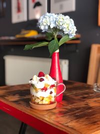 Close-up of food served by flowers in vase on table