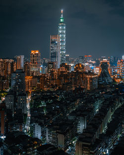 Illuminated buildings in city against sky at night