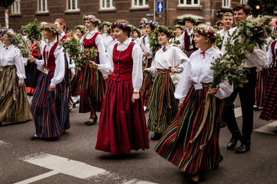 Group of people walking in front of plants