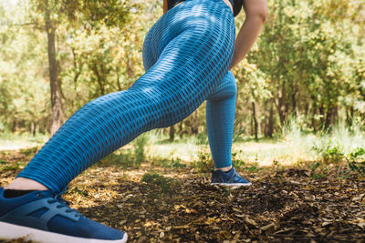 Low section of woman standing on field