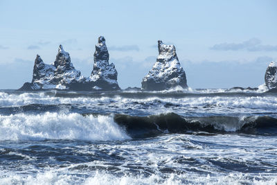 Three pinnacles of vik with rough waves, south iceland in wintertime