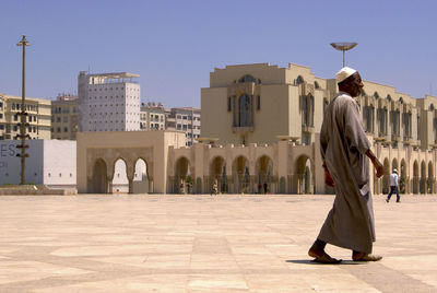 Rear view of woman walking against building