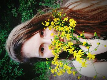 Close-up of young woman with yellow flowers