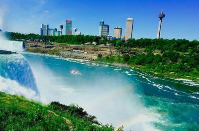 Scenic view of waterfall against sky in city