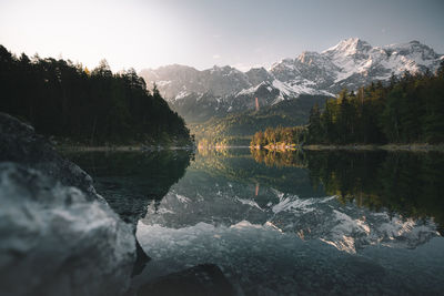 Scenic view of lake by mountains against sky