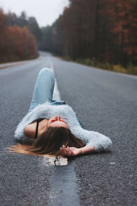 Low section of woman on road in city