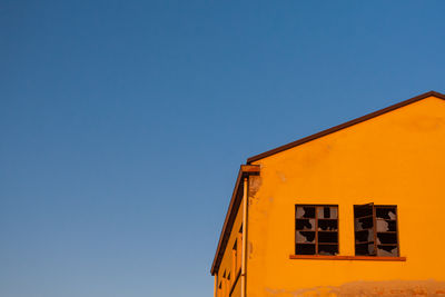 Low angle view of yellow building against clear sky