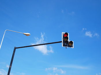 Low angle view of street light against blue sky