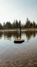 Man in lake against sky