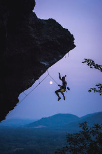 High angle view of people skiing on rock against sky