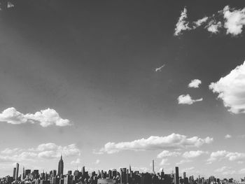 Low angle view of city against cloudy sky