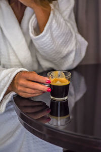 Midsection of woman in bathrobe enjoying a cup of cappuccino in luxury hotel in montreal canada