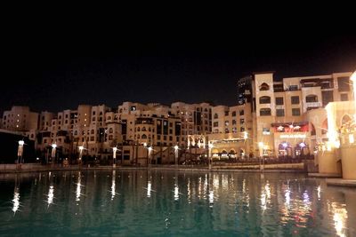 Reflection of buildings in calm water at night