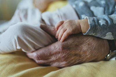 Great granddaughter's hand on great grandmother's hand